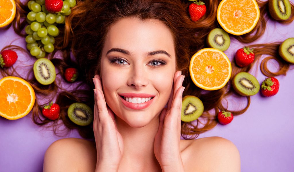 Woman-with-glowing-skin-on-a-background-of-fruit